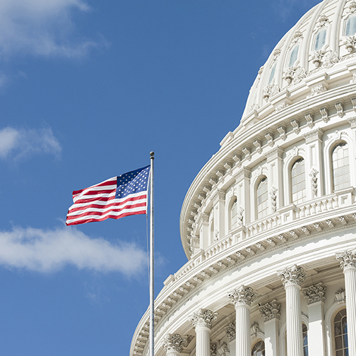 American flag waving in front of Capitol Hill